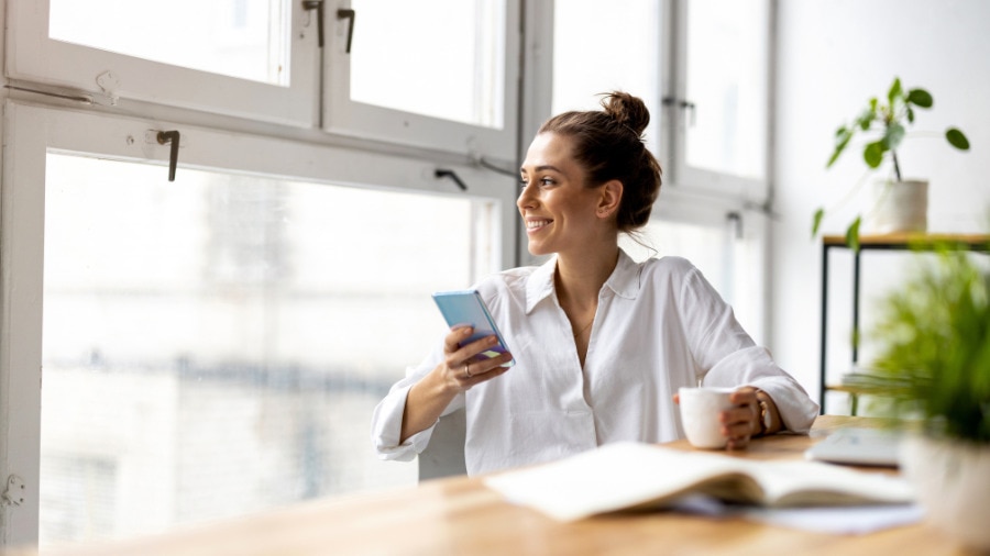 A person sitting at a table with a cell phone.