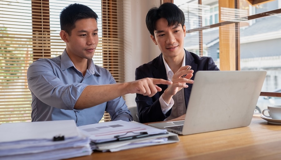 An accountant and his client exploring Intuit Enterprise Suite on the laptop.